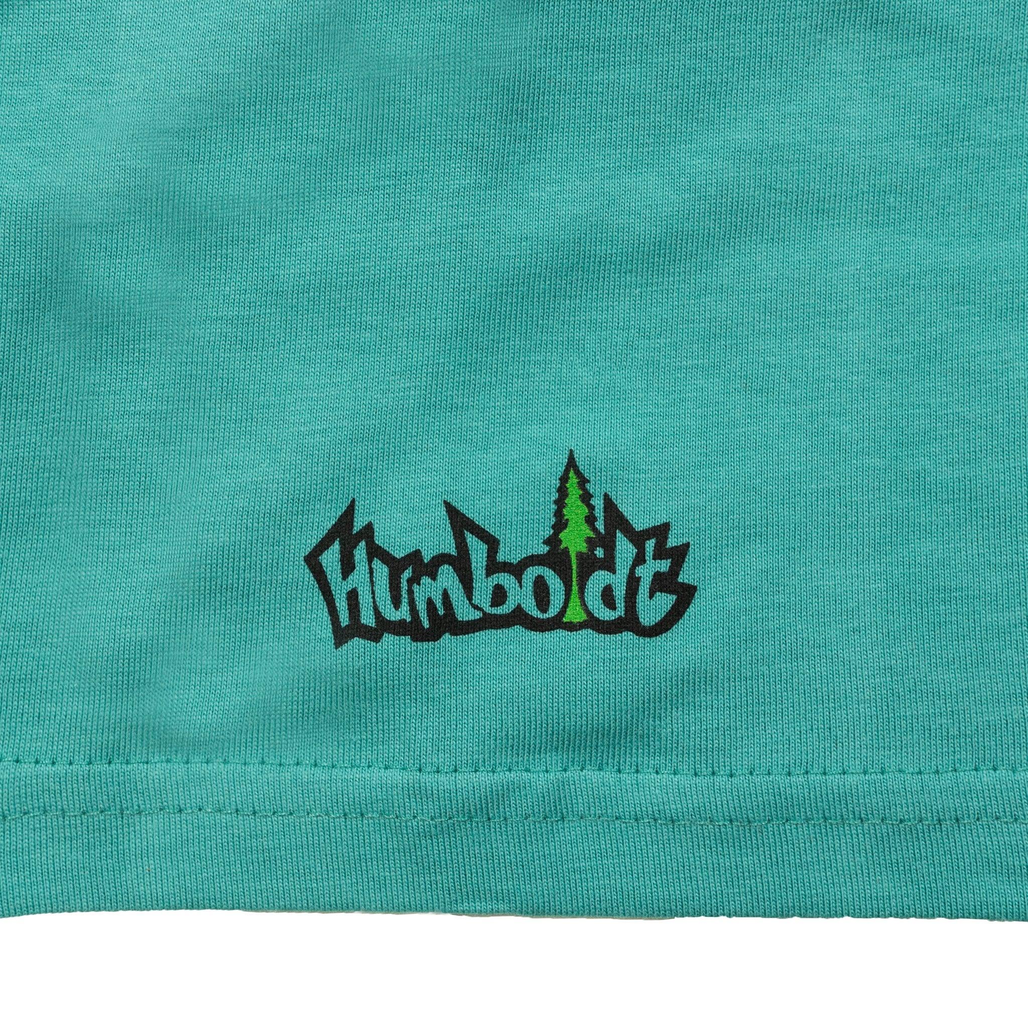 Teal t-shirt with Humboldt logo and green tree graphic, blending outdoor and streetwear style.